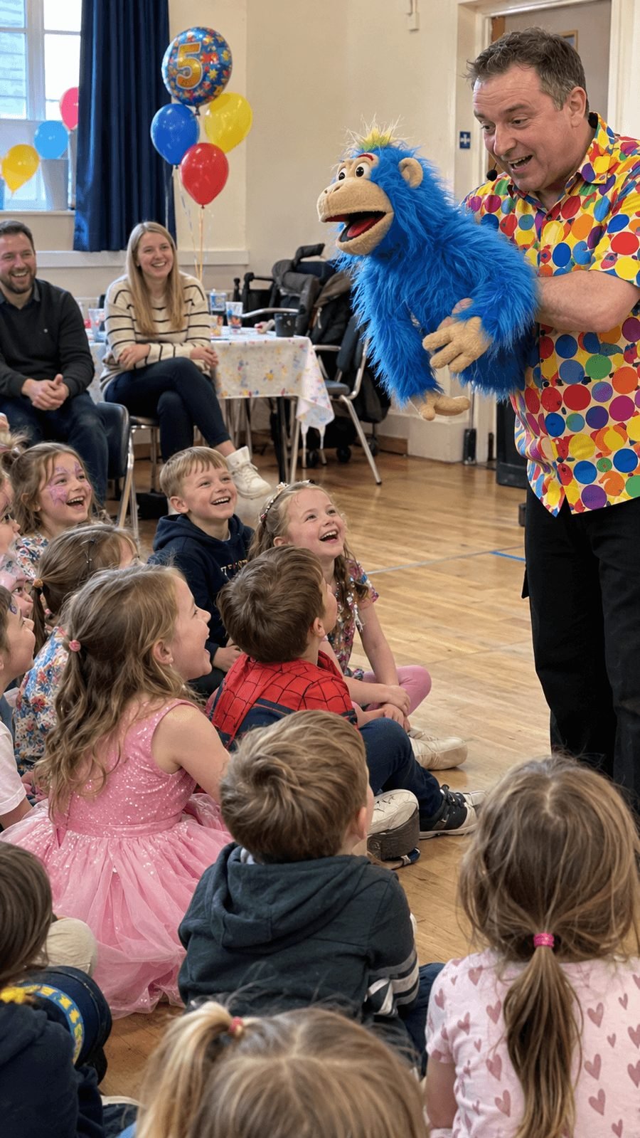 Children laughing at a puppet show at a 5th birthday party