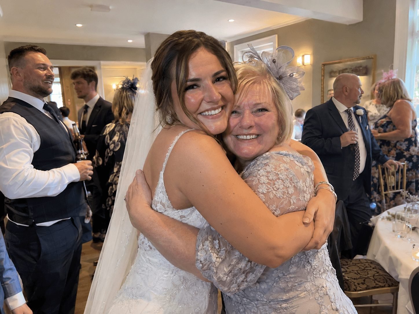 A bride hugging a guest at her wedding