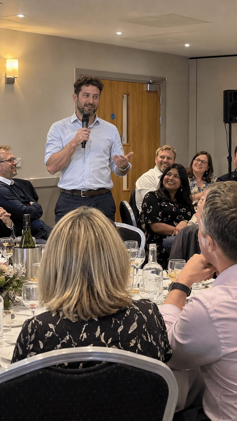 A speech at a company dinner, with colleagues laughing